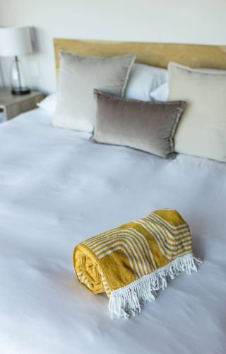 yellow-striped-towel-neatly-folded-on-bed-with-pil-2025-04-05-05-42-15-utc (1)